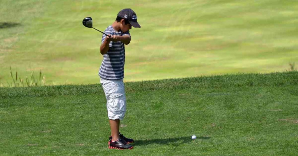 ゴルフをする少年